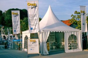 SEJMI: Opazno in zelo drugačno od drugih v okolici na sejmih. FAIRS: Perceivable and different from the others in the surroundings